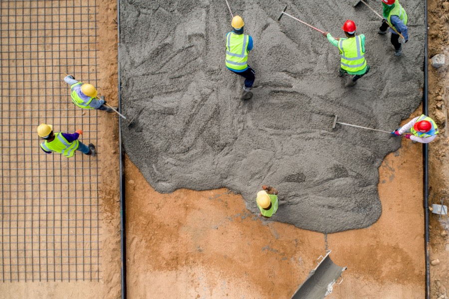 commercial-concrete-pour spreading freshly poured concrete on a commercial building site